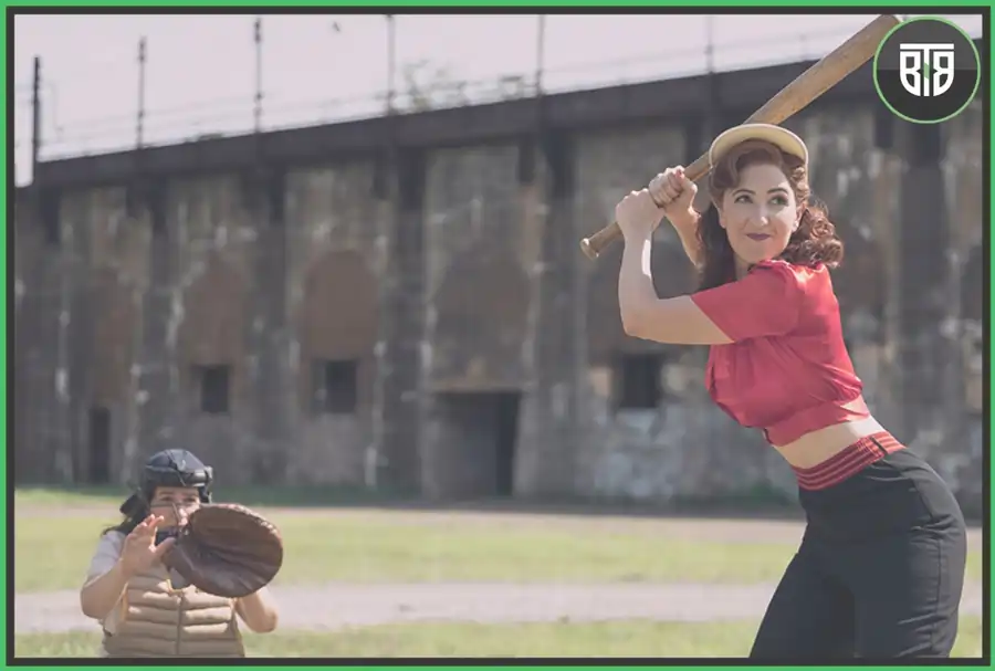 a lady player from baseball is playing her shot and one girl is doing fielding, a league of their own road trip