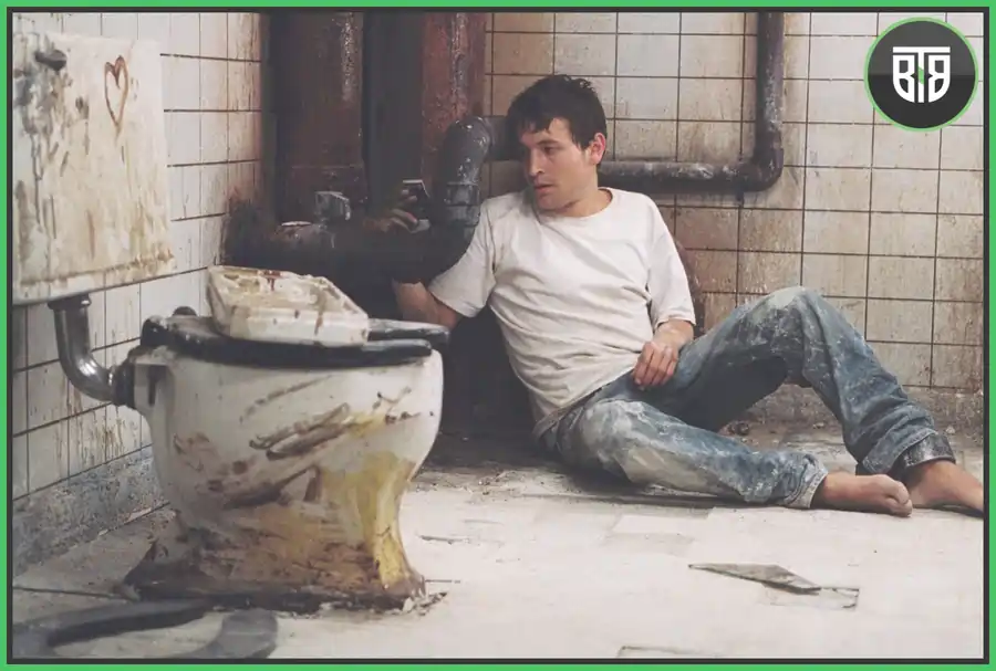 a men is laying near toilet seat in Saw 2004, good horror movies