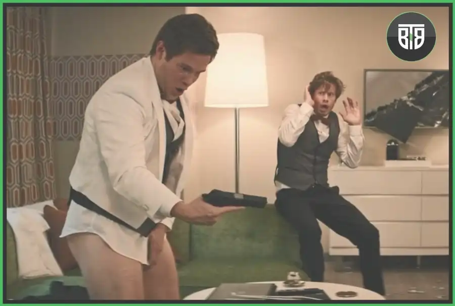 a man is holding a gun without his pants and other one is in fear in  a Movie Game Over, Man! romcom netflix
