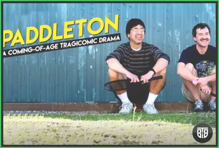two men are sitting, one of them is holding a racket in a movie Paddleton, comedy movies on netflix