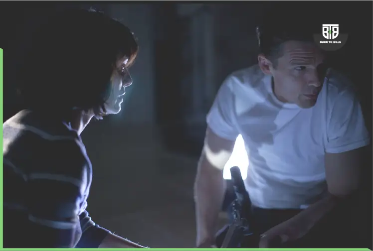 a man and a girl is hiding from something with helping of one torch in a movie the purge