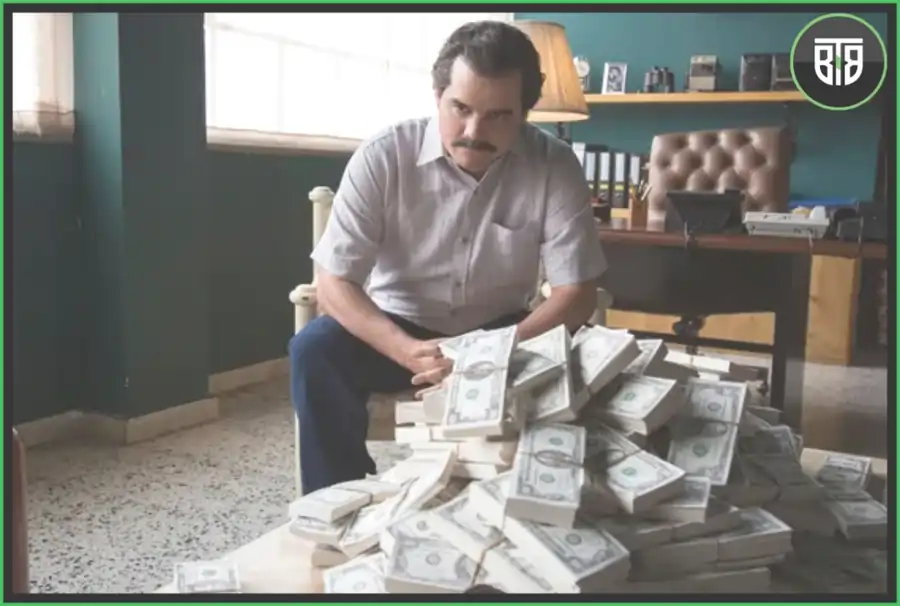 a man is sitting on a chair and in front of him so much cash is split in Narcos, binge worthy shows on netflix