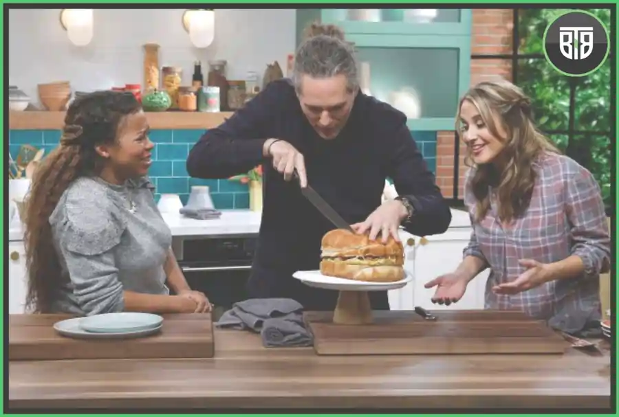 one man is cutting some dish and two ladies are laughing in Tregay's Way in the Kitchedn, discovery channel plus