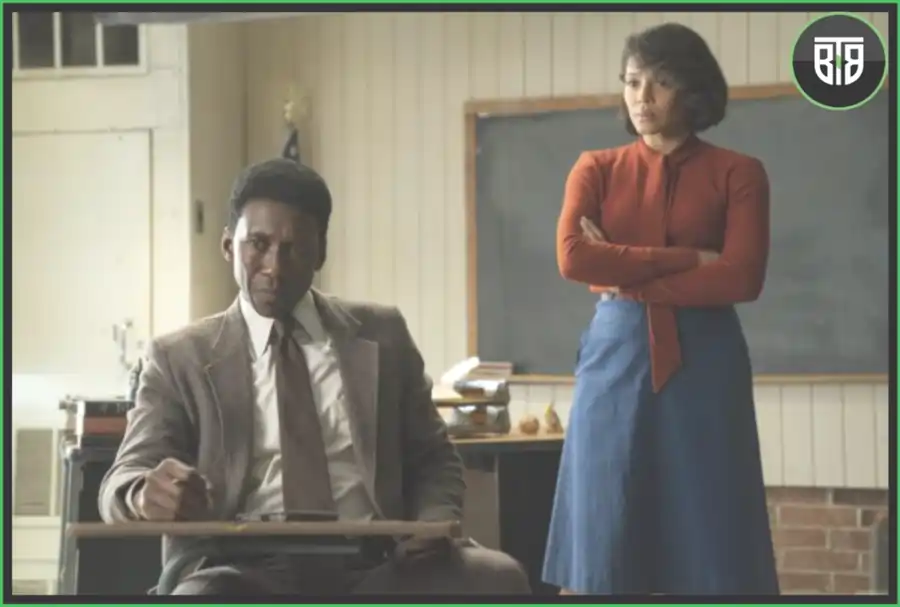 a man is sitting on a chair and a lady is standing behind him in True Detective, binge-worthy shows on netflix